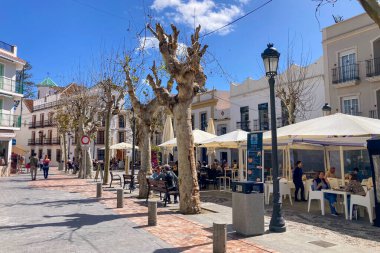 NERJA, İspanya - 22 Mart 2025: Işıldayan deniz ve büyüleyici şehrin muhteşem manzaraları, 22 Mart 2025 tarihinde İspanya 'nın Nerja kentinde nefes kesen kıyı manzaraları ve pitoresk bir atmosfer sunuyor.