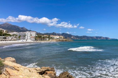 NERJA, İspanya - 22 Mart 2025: Işıldayan deniz ve büyüleyici şehrin muhteşem manzaraları, 22 Mart 2025 tarihinde İspanya 'nın Nerja kentinde nefes kesen kıyı manzaraları ve pitoresk bir atmosfer sunuyor.