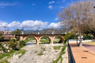 NERJA, İspanya - 22 Mart 2025: Işıldayan deniz ve büyüleyici şehrin muhteşem manzaraları, 22 Mart 2025 tarihinde İspanya 'nın Nerja kentinde nefes kesen kıyı manzaraları ve pitoresk bir atmosfer sunuyor.