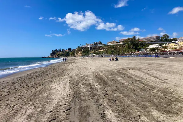 NERJA, İspanya - 22 Mart 2025: Işıldayan deniz ve büyüleyici şehrin muhteşem manzaraları, 22 Mart 2025 tarihinde İspanya 'nın Nerja kentinde nefes kesen kıyı manzaraları ve pitoresk bir atmosfer sunuyor.