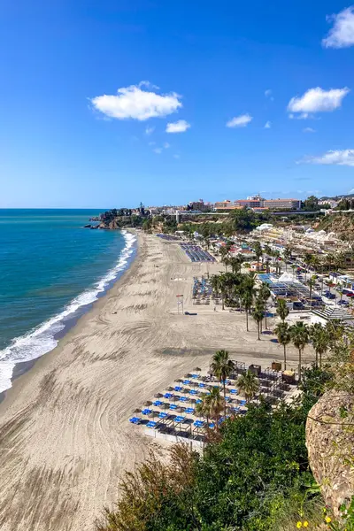 NERJA, İspanya - 22 Mart 2025: Işıldayan deniz ve büyüleyici şehrin muhteşem manzaraları, 22 Mart 2025 tarihinde İspanya 'nın Nerja kentinde nefes kesen kıyı manzaraları ve pitoresk bir atmosfer sunuyor.