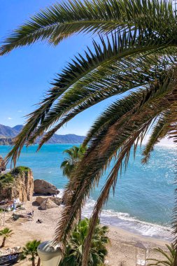 NERJA, İspanya - 22 Mart 2025: Işıldayan deniz ve büyüleyici şehrin muhteşem manzaraları, 22 Mart 2025 tarihinde İspanya 'nın Nerja kentinde nefes kesen kıyı manzaraları ve pitoresk bir atmosfer sunuyor.