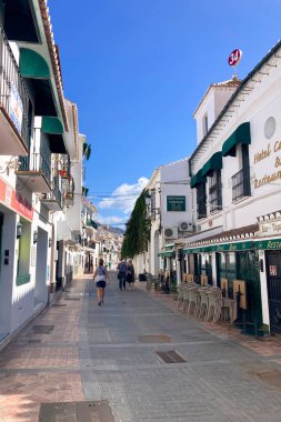 NERJA, İspanya - 22 Mart 2025: Işıldayan deniz ve büyüleyici şehrin muhteşem manzaraları, 22 Mart 2025 tarihinde İspanya 'nın Nerja kentinde nefes kesen kıyı manzaraları ve pitoresk bir atmosfer sunuyor.