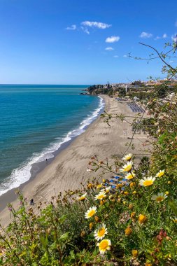 NERJA, İspanya - 22 Mart 2025: Işıldayan deniz ve büyüleyici şehrin muhteşem manzaraları, 22 Mart 2025 tarihinde İspanya 'nın Nerja kentinde nefes kesen kıyı manzaraları ve pitoresk bir atmosfer sunuyor.