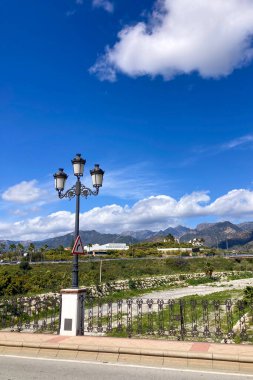 NERJA, İspanya - 22 Mart 2025: Işıldayan deniz ve büyüleyici şehrin muhteşem manzaraları, 22 Mart 2025 tarihinde İspanya 'nın Nerja kentinde nefes kesen kıyı manzaraları ve pitoresk bir atmosfer sunuyor.