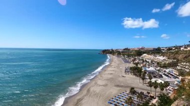NERJA, İspanya - 22 Mart 2025: Işıldayan deniz ve büyüleyici şehrin muhteşem manzaraları, 22 Mart 2025 tarihinde İspanya 'nın Nerja kentinde nefes kesen kıyı manzaraları ve pitoresk bir atmosfer sunuyor.