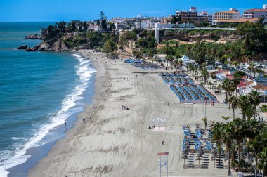 NERJA, İspanya - 22 Mart 2025: Işıldayan deniz ve büyüleyici şehrin muhteşem manzaraları, 22 Mart 2025 tarihinde İspanya 'nın Nerja kentinde nefes kesen kıyı manzaraları ve pitoresk bir atmosfer sunuyor.