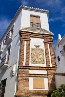 FRIGILIANA, SPAIN - 10 Mayıs 2025: Frigiliana, İspanya 'da beyazlatılmış evler ve renkli çiçeklerle çevrili büyüleyici dar sokaklarda huzurlu bir yürüyüş