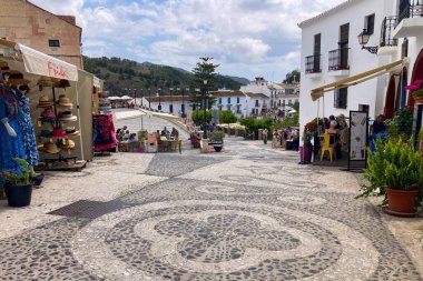 FRIGILIANA, SPAIN - 10 Mayıs 2025: Frigiliana, İspanya 'da beyazlatılmış evler ve renkli çiçeklerle çevrili büyüleyici dar sokaklarda huzurlu bir yürüyüş