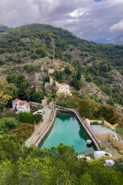 FRIGILIANA, İspanya - 10 Mayıs 2025: Frigiliana, İspanya 'daki eski bir sulama hendeği boyunca bir yürüyüş yolunun çevresindeki dağların ve pitoresk köyün manzarası.