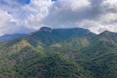 İspanya 'nın Frigiliana kentindeki eski bir sulama hendeği boyunca bir yürüyüş yolundan çevresindeki dağların ve resimli köyün manzarası..