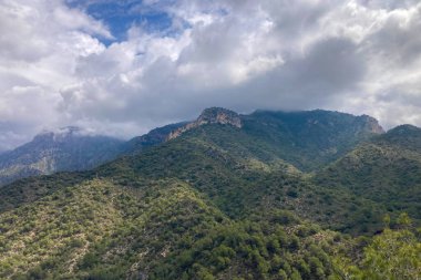 İspanya 'nın Frigiliana kentindeki eski bir sulama hendeği boyunca bir yürüyüş yolundan çevresindeki dağların ve resimli köyün manzarası..
