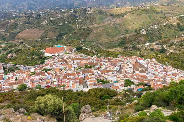 FRIGILIANA, SPAIN - 10 Mayıs 2025: Frigiliana, İspanya 'da beyazlatılmış evler ve renkli çiçeklerle çevrili büyüleyici dar sokaklarda huzurlu bir yürüyüş