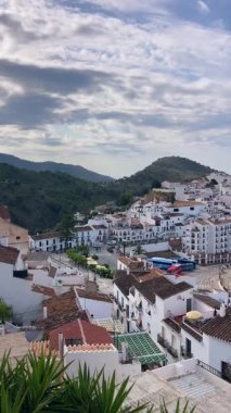 FRIGILIANA, SPAIN - 10 Mayıs 2025: Frigiliana, İspanya 'da beyazlatılmış evler ve renkli çiçeklerle çevrili büyüleyici dar sokaklarda huzurlu bir yürüyüş