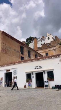 FRIGILIANA, SPAIN - 10 Mayıs 2025: Frigiliana, İspanya 'da beyazlatılmış evler ve renkli çiçeklerle çevrili büyüleyici dar sokaklarda huzurlu bir yürüyüş