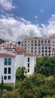 FRIGILIANA, SPAIN - 10 Mayıs 2025: Frigiliana, İspanya 'da beyazlatılmış evler ve renkli çiçeklerle çevrili büyüleyici dar sokaklarda huzurlu bir yürüyüş