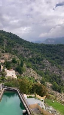 İspanya 'nın Frigiliana kentindeki eski bir sulama hendeği boyunca bir yürüyüş yolundan çevresindeki dağların ve resimli köyün manzarası..