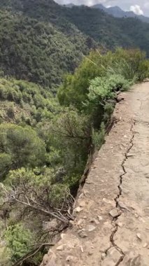 İspanya 'nın Frigiliana kentindeki eski bir sulama hendeği boyunca bir yürüyüş yolundan çevresindeki dağların ve resimli köyün manzarası..