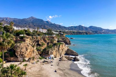 NERJA, İspanya - 22 Mart 2025: Işıldayan deniz ve büyüleyici şehrin muhteşem manzaraları, 22 Mart 2025 tarihinde İspanya 'nın Nerja kentinde nefes kesen kıyı manzaraları ve pitoresk bir atmosfer sunuyor.