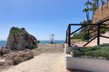 NERJA, İspanya - 22 Mart 2025: Işıldayan deniz ve büyüleyici şehrin muhteşem manzaraları, 22 Mart 2025 tarihinde İspanya 'nın Nerja kentinde nefes kesen kıyı manzaraları ve pitoresk bir atmosfer sunuyor.