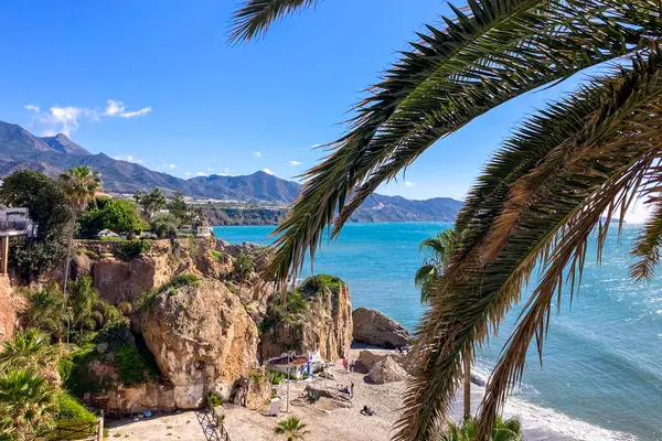 NERJA, İspanya - 22 Mart 2025: Işıldayan deniz ve büyüleyici şehrin muhteşem manzaraları, 22 Mart 2025 tarihinde İspanya 'nın Nerja kentinde nefes kesen kıyı manzaraları ve pitoresk bir atmosfer sunuyor.