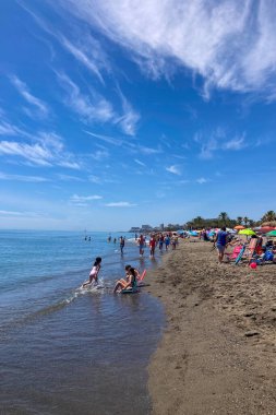 TORREMOLINOS, İSPAN - 14 Mayıs 2025: güneşli sahilde dinlenmek, İspanya 'nın Torremolinos kentindeki huzurlu sahil atmosferinin tadını çıkarmak