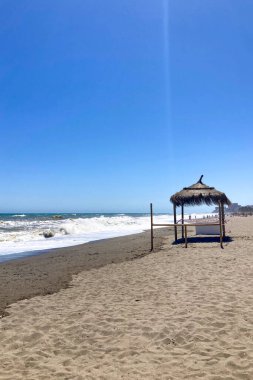 TORREMOLINOS, SPAIN - 30 Nisan 2025: Canlı şehir merkezinden manzaralı deniz geçidine doğru sakin bir yürüyüş yapmak, İspanya 'nın Torremolinos kentindeki büyüleyici sahil atmosferinde ıslanmak.