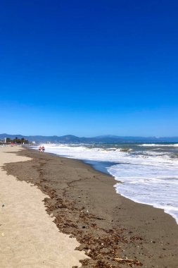 TORREMOLINOS, SPAIN - 30 Nisan 2025: Canlı şehir merkezinden manzaralı deniz geçidine doğru sakin bir yürüyüş yapmak, İspanya 'nın Torremolinos kentindeki büyüleyici sahil atmosferinde ıslanmak.