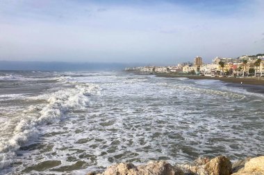 İspanya 'nın Torremolinos kentindeki büyüleyici sahil atmosferinde deniz fırtınası sırasında manzaralı deniz gezintisinin keyfini çıkarıyorum..