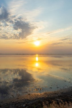 Lebedivka, Ukrayna 'daki Tuzlivsky haliçleri üzerinde altın gün batımı huzurlu ve pitoresk bir doğal manzara yaratıyor..