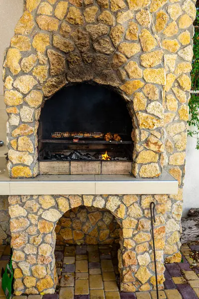 Doğal taştan yapılmış, ızgara yapmak ve toplamak için mükemmel, kırsal bir barbekü şöminesi..
