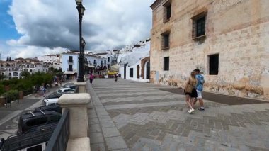 FRIGILIANA, SPAIN - 10 Mayıs 2025: Frigiliana, İspanya 'da beyazlatılmış evler ve renkli çiçeklerle çevrili büyüleyici dar sokaklarda huzurlu bir yürüyüş