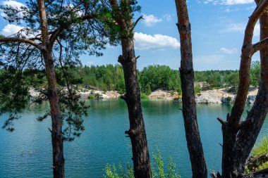 KOROSTYSHIV, UKRAINE - 21 Haziran 2020: Terk edilmiş Korostyshiv taş ocağı, derin mavi suları ve engebeli uçurumlarıyla dinlenme, balık tutma ve yüzme için manzaralı bir yer haline geldi..