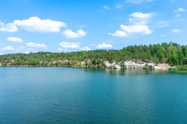 KOROSTYSHIV, UKRAINE - 21 Haziran 2020: Terk edilmiş Korostyshiv taş ocağı, derin mavi suları ve engebeli uçurumlarıyla dinlenme, balık tutma ve yüzme için manzaralı bir yer haline geldi..