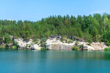 KOROSTYSHIV, UKRAINE - 21 Haziran 2020: Terk edilmiş Korostyshiv taş ocağı, derin mavi suları ve engebeli uçurumlarıyla dinlenme, balık tutma ve yüzme için manzaralı bir yer haline geldi..