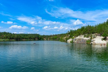 Derin mavi suları ve engebeli uçurumlarıyla terk edilmiş Korostyshiv taş ocağı dinlenme, balık tutma ve yüzme için manzaralı bir yer haline geldi..