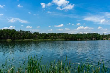 KOROSTYSHIV, UKRAINE - 21 Haziran 2020: Terk edilmiş Korostyshiv taş ocağı, derin mavi suları ve engebeli uçurumlarıyla dinlenme, balık tutma ve yüzme için manzaralı bir yer haline geldi..