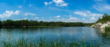 KOROSTYSHIV, UKRAINE - 21 Haziran 2020: Terk edilmiş Korostyshiv taş ocağı, derin mavi suları ve engebeli uçurumlarıyla dinlenme, balık tutma ve yüzme için manzaralı bir yer haline geldi..