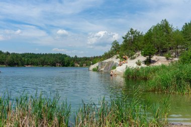KOROSTYSHIV, UKRAINE - 21 Haziran 2020: Terk edilmiş Korostyshiv taş ocağı, derin mavi suları ve engebeli uçurumlarıyla dinlenme, balık tutma ve yüzme için manzaralı bir yer haline geldi..