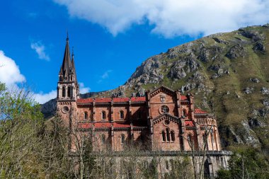 COVADONGA, İspanya - 6 Nisan 2025: Asturias 'taki Covadonga kutsal mağarası, bazilikası ve çarpıcı doğal çevresiyle bilinen tarihi bir dağ köyüdür..