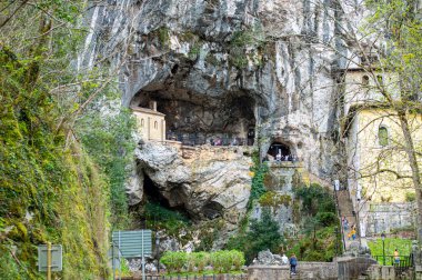 COVADONGA, İspanya - 6 Nisan 2025: Asturias 'taki Covadonga kutsal mağarası, bazilikası ve çarpıcı doğal çevresiyle bilinen tarihi bir dağ köyüdür..