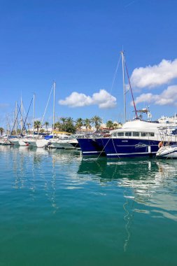 BENALMADENA, SPAIN - 24 Mayıs 2025 İspanya 'nın canlı limanı Benalmadena' da, kıyı cazibesi ve deniz zarafeti ile çevrili demirlemiş yatlar arasında rahatlatıcı bir yürüyüş yapmak.