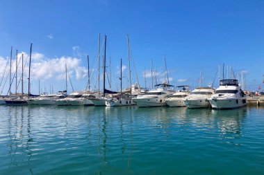 BENALMADENA, SPAIN - 24 Mayıs 2025 İspanya 'nın canlı limanı Benalmadena' da, kıyı cazibesi ve deniz zarafeti ile çevrili demirlemiş yatlar arasında rahatlatıcı bir yürüyüş yapmak.