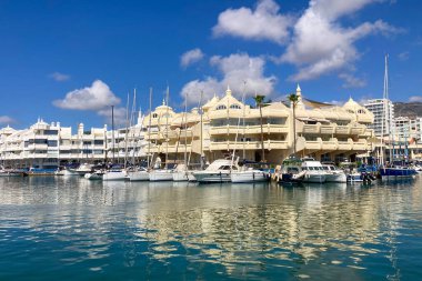 BENALMADENA, SPAIN - 24 Mayıs 2025 İspanya 'nın canlı limanı Benalmadena' da, kıyı cazibesi ve deniz zarafeti ile çevrili demirlemiş yatlar arasında rahatlatıcı bir yürüyüş yapmak.