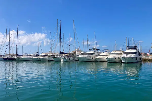 BENALMADENA, SPAIN - 24 Mayıs 2025 İspanya 'nın canlı limanı Benalmadena' da, kıyı cazibesi ve deniz zarafeti ile çevrili demirlemiş yatlar arasında rahatlatıcı bir yürüyüş yapmak.