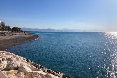 TORREMOLINOS, SPAIN - 24 Mayıs 2025: İspanya 'nın Torremolinos kıyı şeridi boyunca huzurlu bir yürüyüş, manzaralı ve ferahlatıcı bir deniz meltemi.