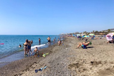 TORREMOLINOS, SPAIN - 24 Mayıs 2025: İspanya 'nın Torremolinos kıyı şeridi boyunca huzurlu bir yürüyüş, manzaralı ve ferahlatıcı bir deniz meltemi.