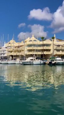BENALMADENA, SPAIN - 24 Mayıs 2025 İspanya 'nın canlı limanı Benalmadena' da, kıyı cazibesi ve deniz zarafeti ile çevrili demirlemiş yatlar arasında rahatlatıcı bir yürüyüş yapmak.