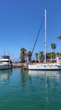 BENALMADENA, SPAIN - 24 Mayıs 2025 İspanya 'nın canlı limanı Benalmadena' da, kıyı cazibesi ve deniz zarafeti ile çevrili demirlemiş yatlar arasında rahatlatıcı bir yürüyüş yapmak.