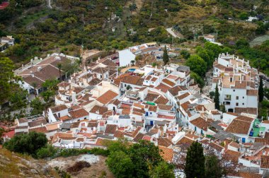 İspanya 'nın Frigiliana kentindeki eski bir sulama hendeği boyunca bir yürüyüş yolundan çevresindeki dağların ve resimli köyün manzarası..